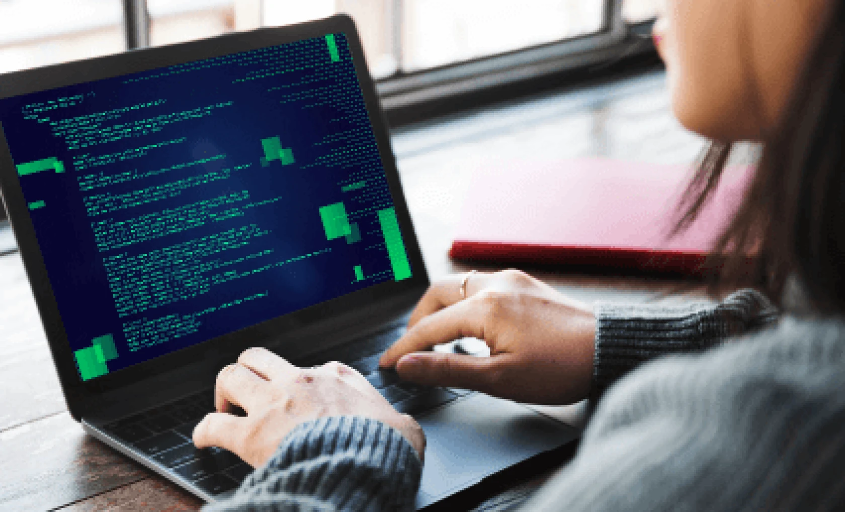 Person working with computer code on a laptop.
