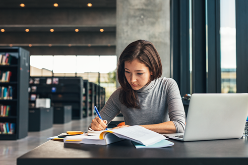 Young woman study with a laptop in a library.