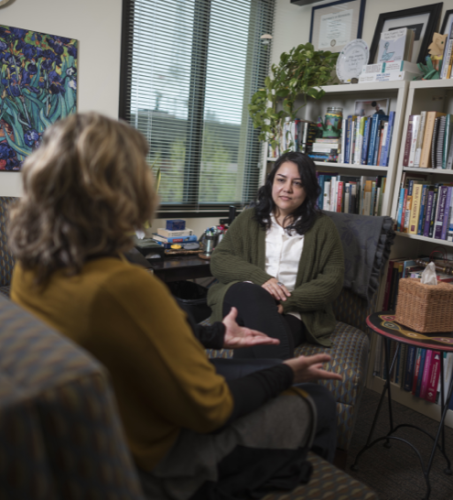 Photo of counselor listening to a student in their office.